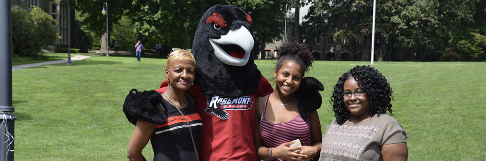 A family poses with Rosemont College masot Renny the Raven