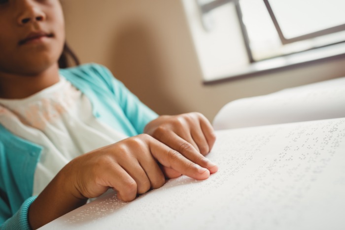 African-American child reading braille. 