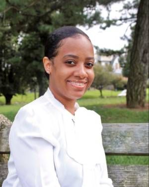 A hadshot of Stephanie Jones, a black woman in a white blouse. She's smiling and standing outside.